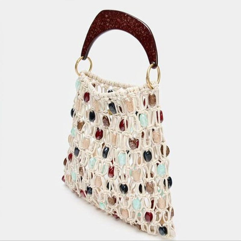 Woven handbag with multicolored stones and brown handle on a white background